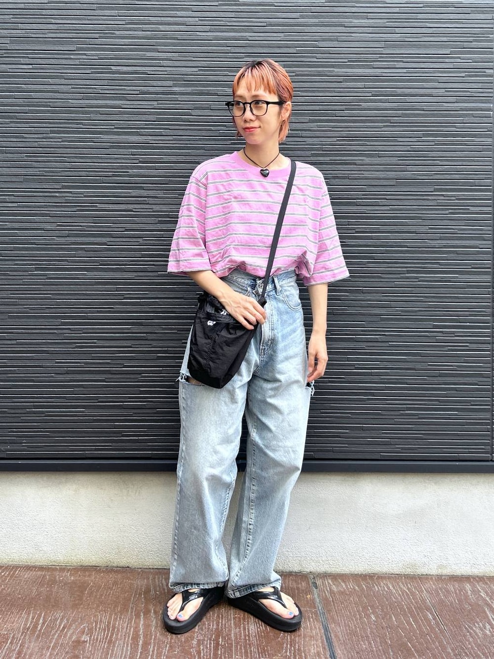 ピンク系のTシャツ/カットソー、ブラック系のショルダーバッグ、ブルー系のデニムパンツを着用したレディースの夏コーディネートの1枚目の写真