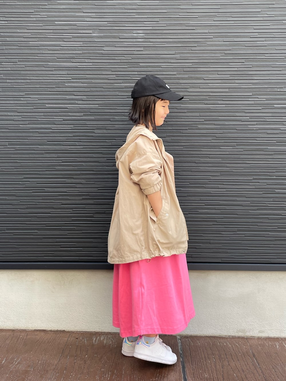 ピンク系のワンピース、ベージュ系のブルゾン、ホワイト系のスニーカーを着用したレディースの春コーディネートの5枚目の写真