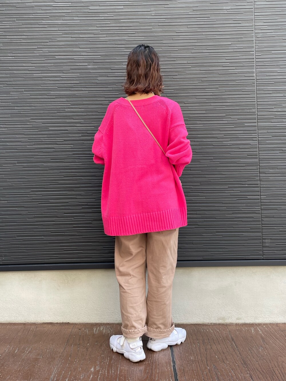 ピンク系のワンピース、ベージュ系のブルゾン、ホワイト系のスニーカーを着用したレディースの春コーディネートの3枚目の写真