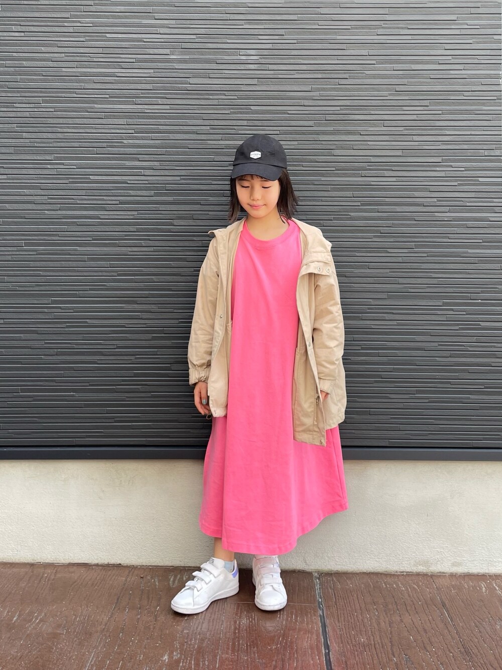 ピンク系のワンピース、ベージュ系のブルゾン、ホワイト系のスニーカーを着用したレディースの春コーディネートの4枚目の写真