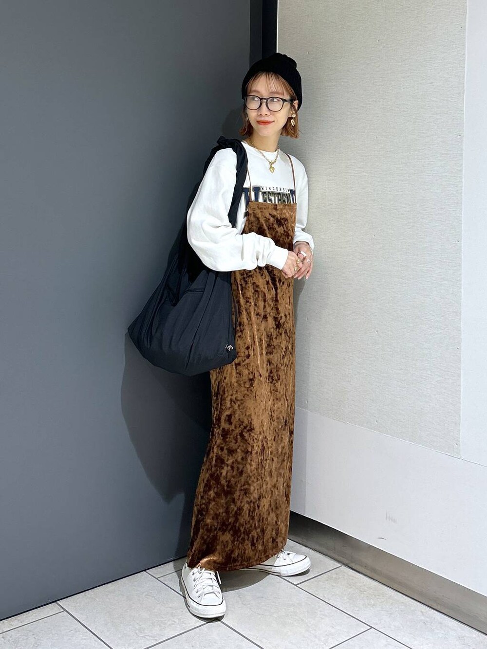 ブラウン系のワンピース、ホワイト系のスウェット、ブラック系のショルダーバッグを着用したレディースの秋コーディネートの1枚目の写真