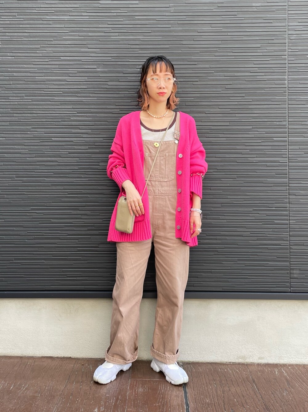 ピンク系のワンピース、ベージュ系のブルゾン、ホワイト系のスニーカーを着用したレディースの春コーディネートの2枚目の写真