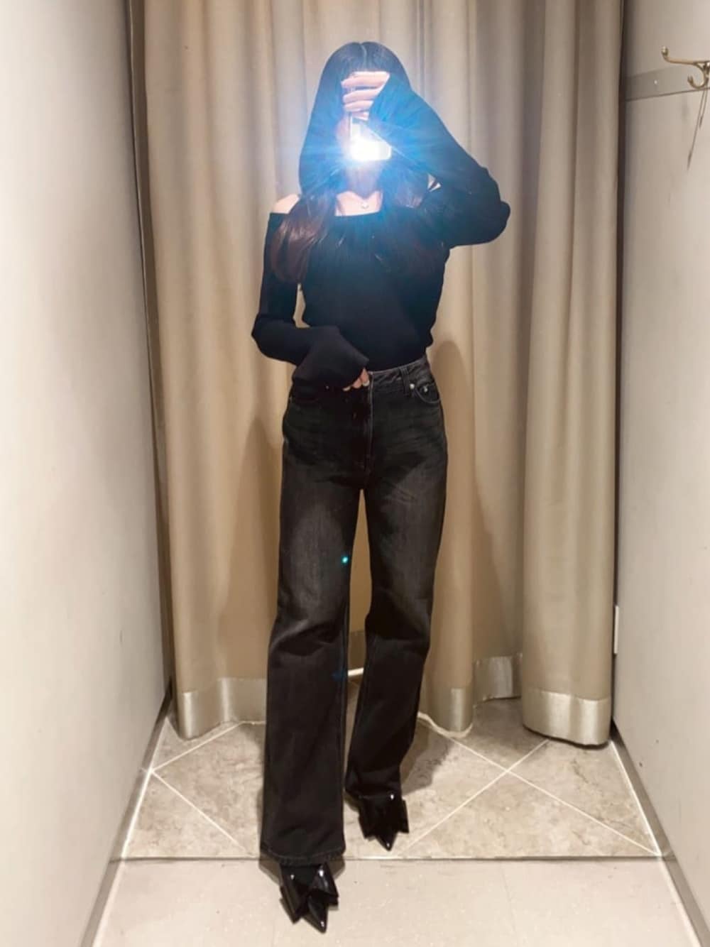 ブラック系のニット/セーター、ブラック系のデニムパンツ、ブラック系のパンプスを着用したレディースの冬コーディネートの1枚目の写真