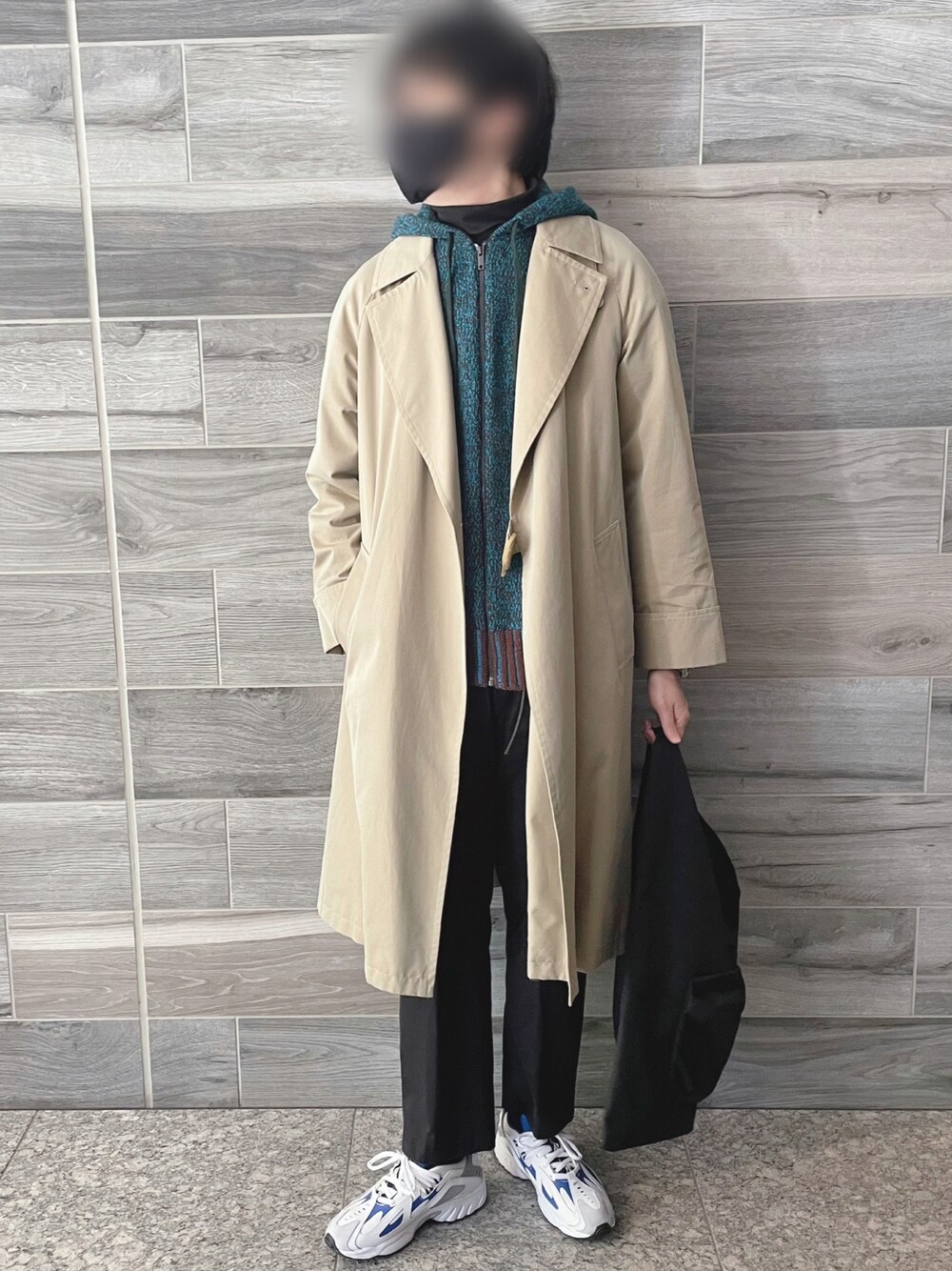 ブルー系のパーカー、ベージュ系のトレンチコート、ブラック系のスラックスを着用したメンズの冬コーディネートの1枚目の写真