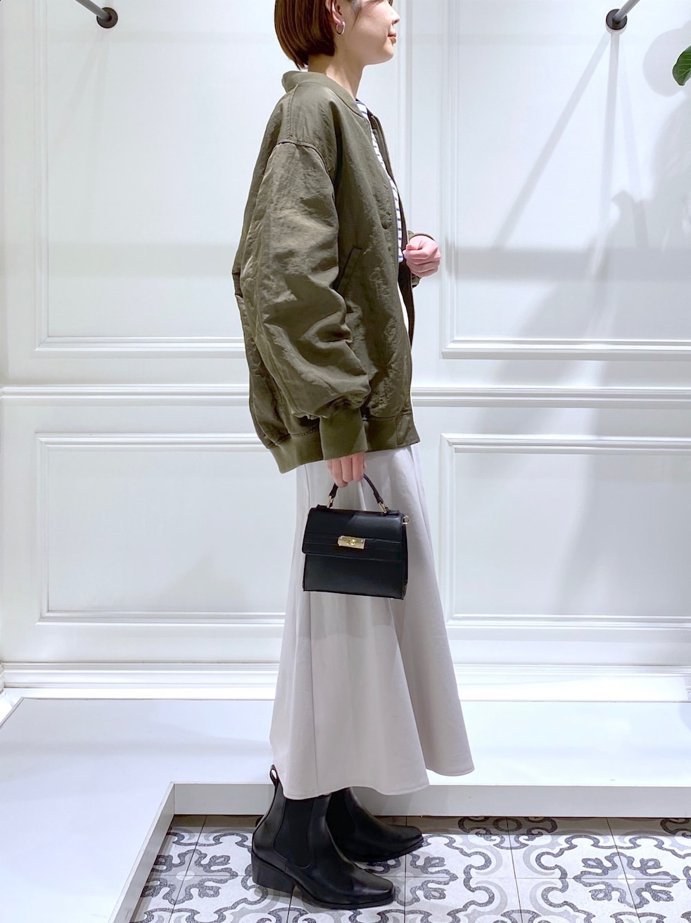 グリーン系のMA-1、ブルー系のTシャツ/カットソー、ホワイト系のワンピースを着用したレディースの冬コーディネートの4枚目の写真