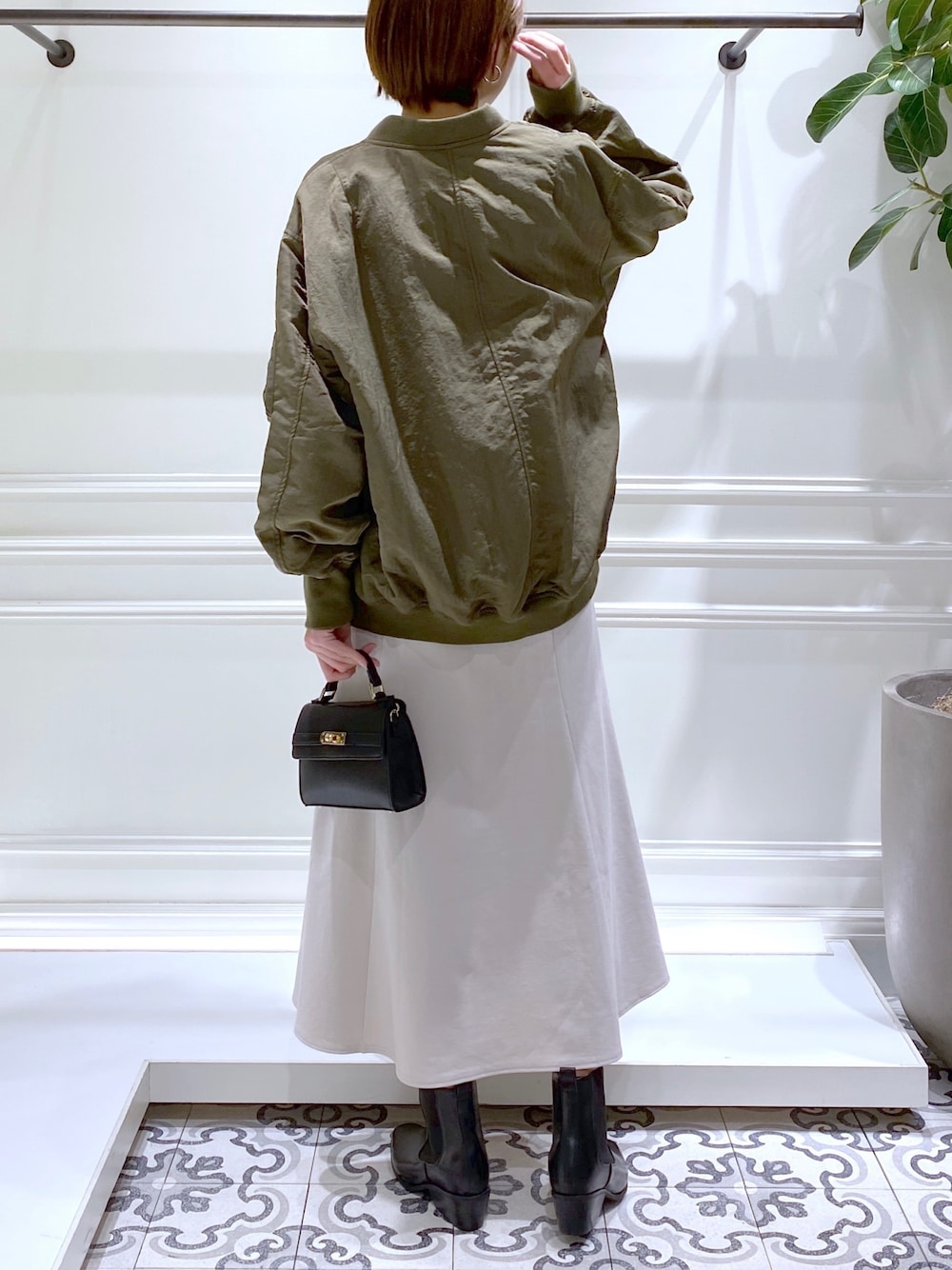 グリーン系のMA-1、ブルー系のTシャツ/カットソー、ホワイト系のワンピースを着用したレディースの冬コーディネートの5枚目の写真