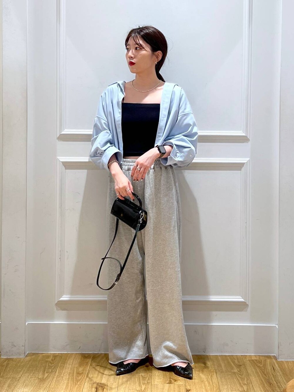 ブルー系のシャツ/ブラウス、グレー系のスウェットパンツ、ブラック系のショルダーバッグを着用したレディースの秋コーディネートの1枚目の写真