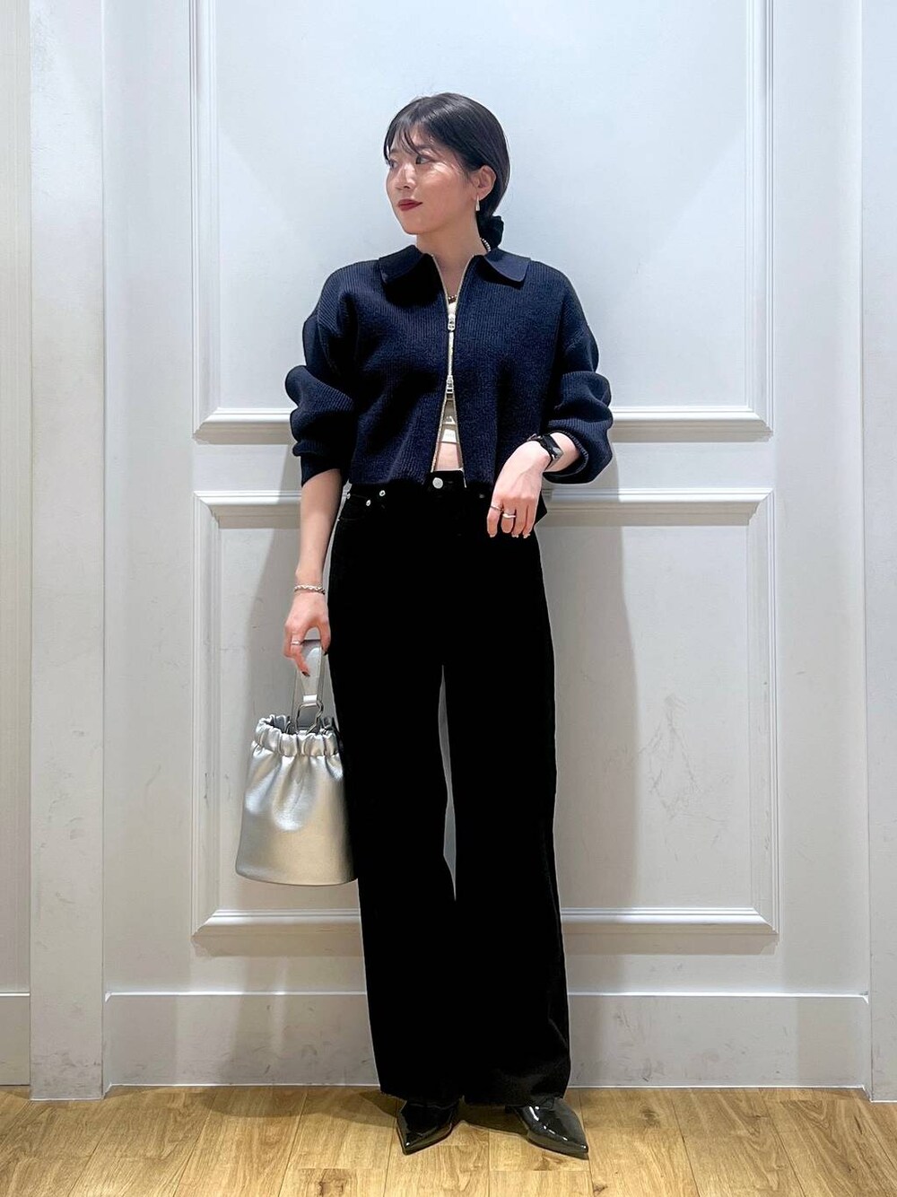 ブラック系のデニムパンツ、ブルー系のカーディガン/ボレロ、シルバー系のショルダーバッグを着用したレディースの秋コーディネートの1枚目の写真