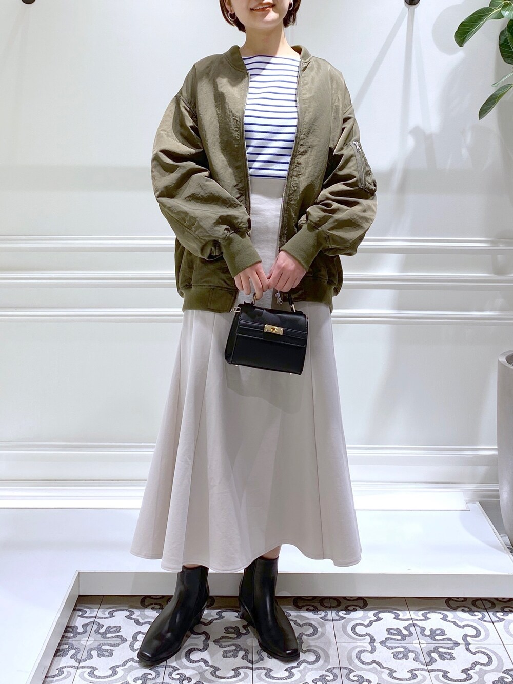 グリーン系のMA-1、ブルー系のTシャツ/カットソー、ホワイト系のワンピースを着用したレディースの冬コーディネートの2枚目の写真