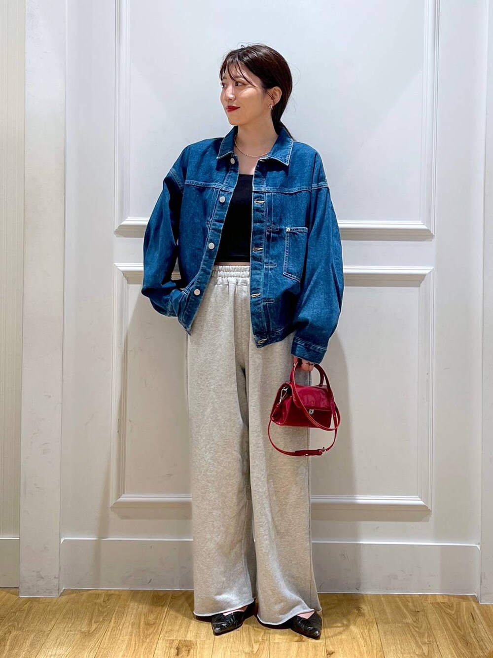 ブルー系のデニムジャケット、グレー系のスウェットパンツ、ブラウン系のショルダーバッグを着用したレディースの秋コーディネートの1枚目の写真