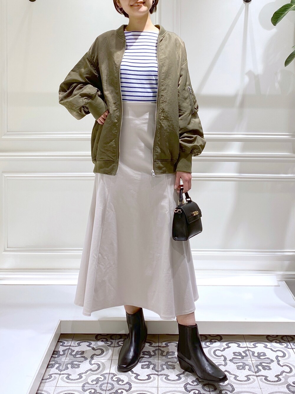 グリーン系のMA-1、ブルー系のTシャツ/カットソー、ホワイト系のワンピースを着用したレディースの冬コーディネートの3枚目の写真