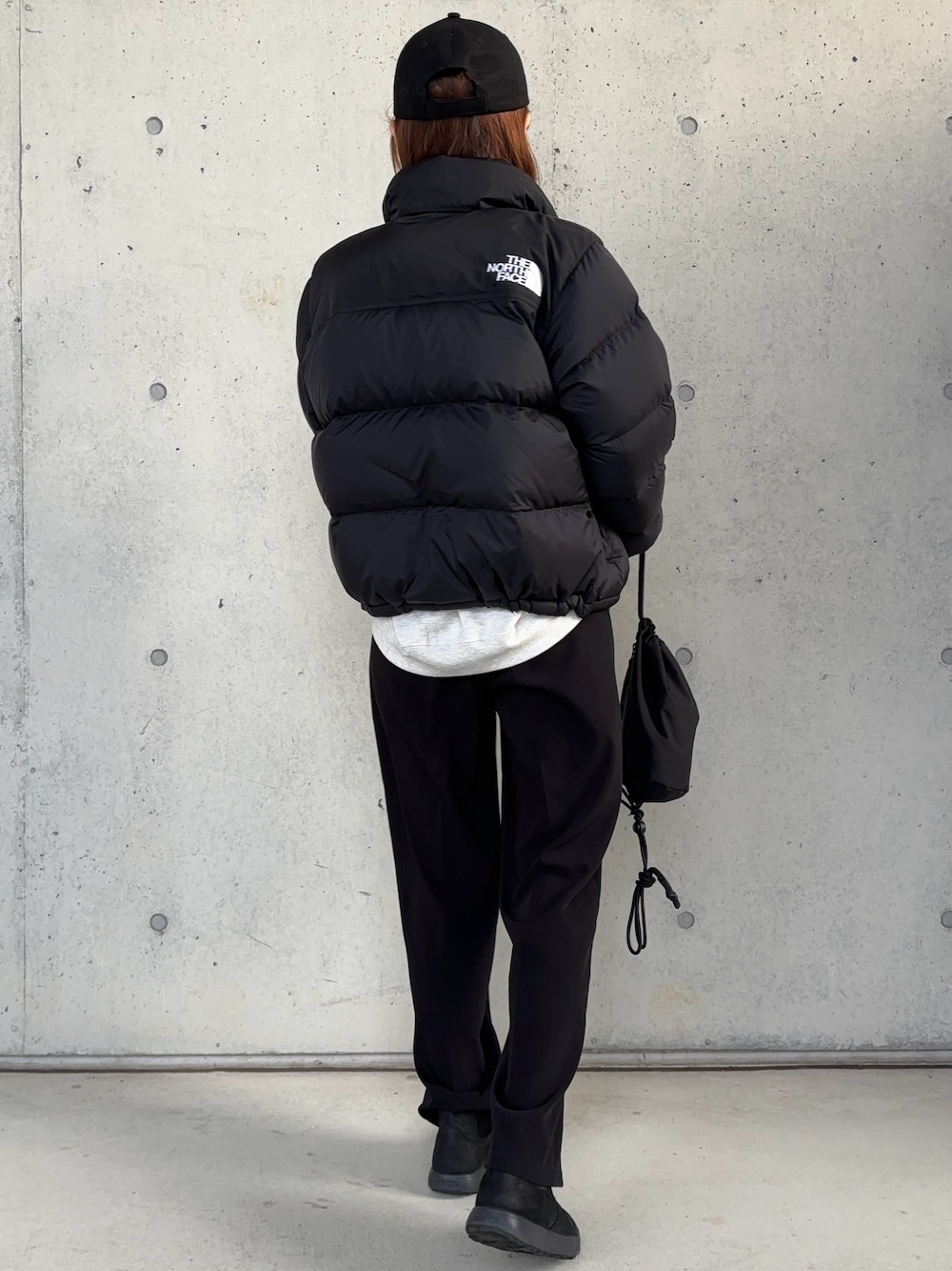 ブラック系のダウンジャケット/コート、ブラック系のブーツ、ブラック系のショルダーバッグを着用したレディースの冬コーディネートの1枚目の写真