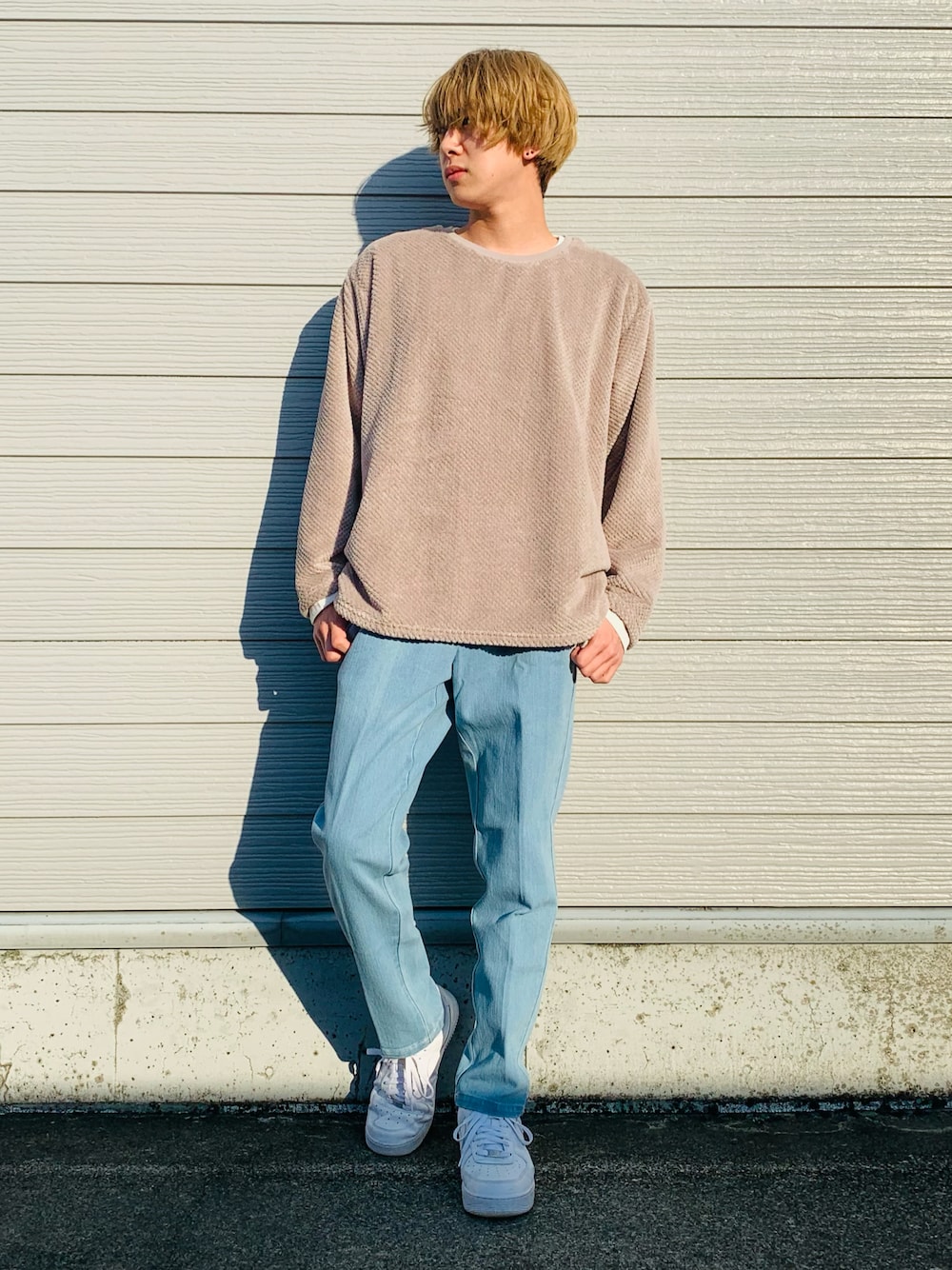 ホワイト系のスニーカー、ブルー系のデニムパンツ、グレー系のアンサンブルを着用したメンズの秋コーディネートの1枚目の写真