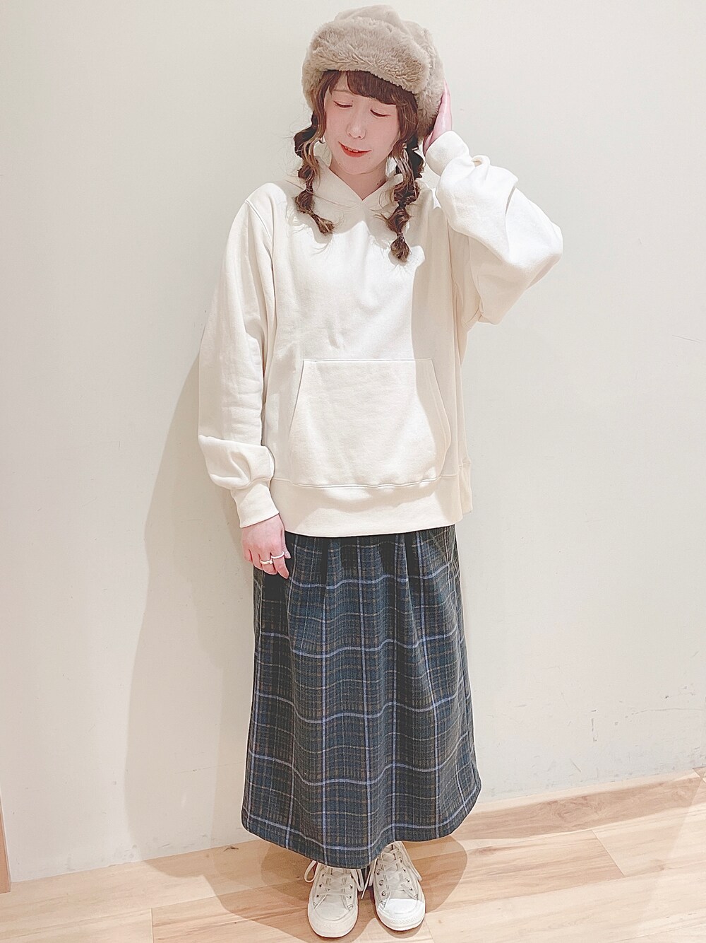 ホワイト系のパーカー、グリーン系のスカート、ホワイト系のスニーカーを着用したレディースの秋コーディネートの1枚目の写真