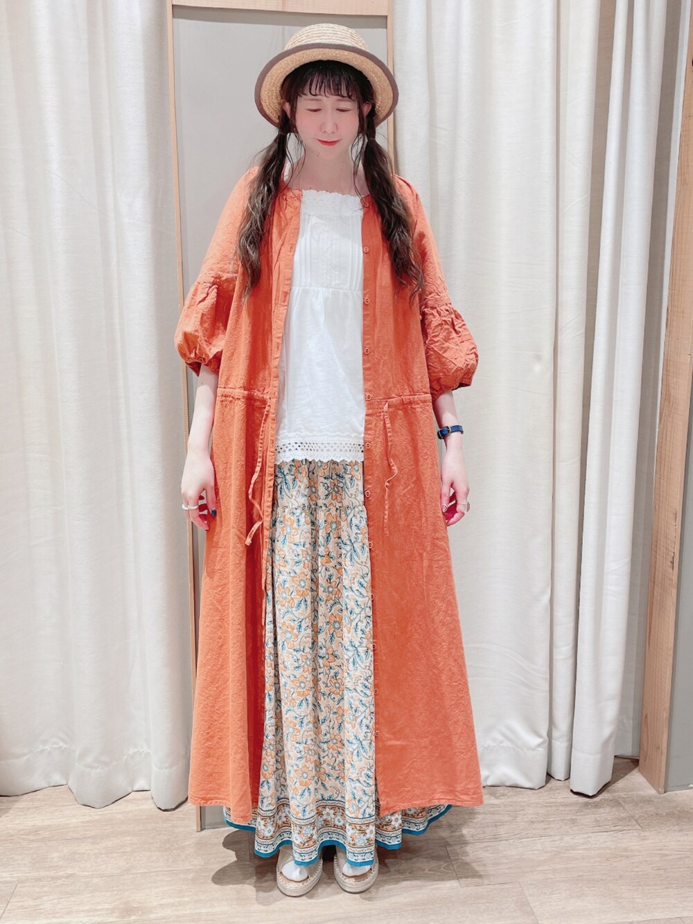 ホワイト系のTシャツ/カットソー、オレンジ系のワンピース、イエロー系のスカートを着用したレディースの春コーディネートの1枚目の写真