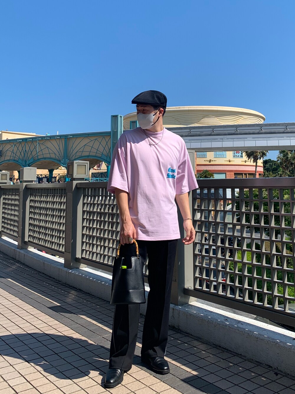 ピンク系のTシャツ/カットソー、ブラック系のハンドバッグ、ブラック系のスラックスを着用したメンズの夏コーディネートの1枚目の写真