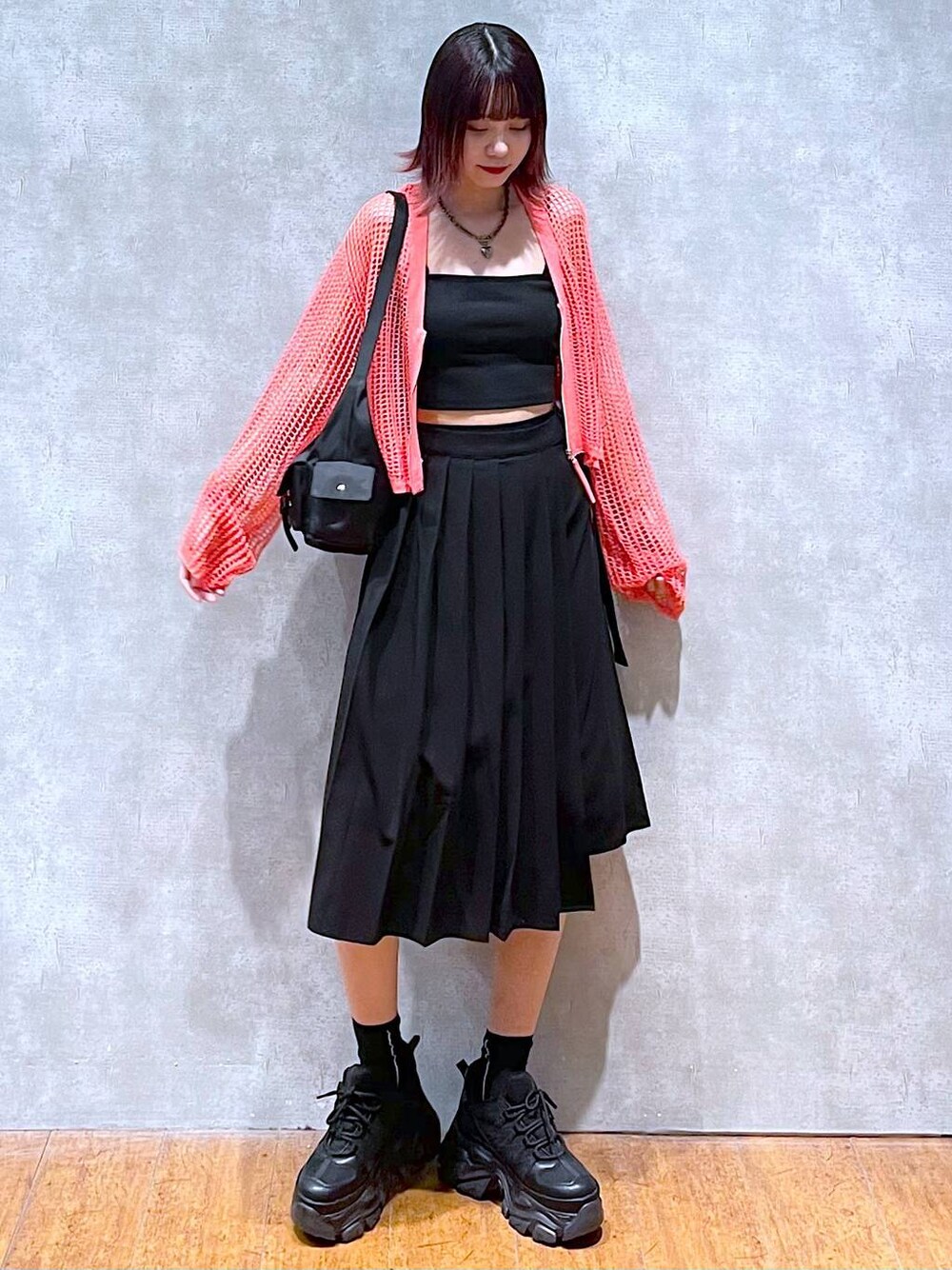 ブラック系のショルダーバッグ、ピンク系のカーディガン/ボレロ、ブラック系のキャミソールを着用したレディースの春コーディネートの1枚目の写真
