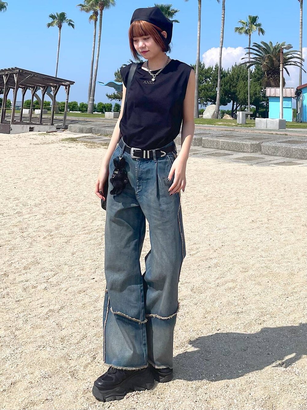 ブラック系のショルダーバッグ、ブラック系のスニーカー、オレンジ系のデニムパンツを着用したレディースの夏コーディネートの1枚目の写真