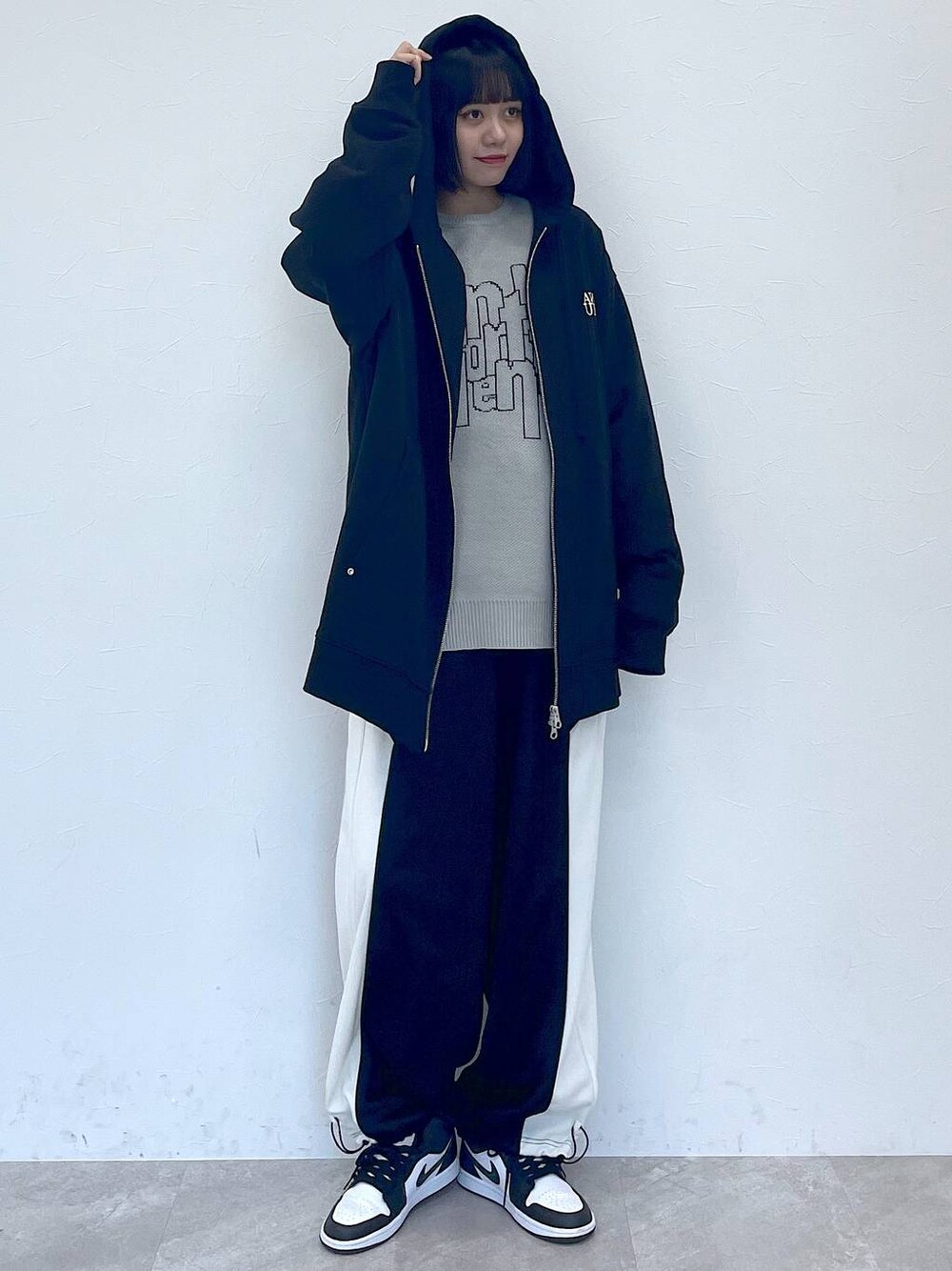 ブラック系のパーカー、ブラック系のその他パンツ、グレー系のニット/セーターを着用したレディースの冬コーディネートの1枚目の写真