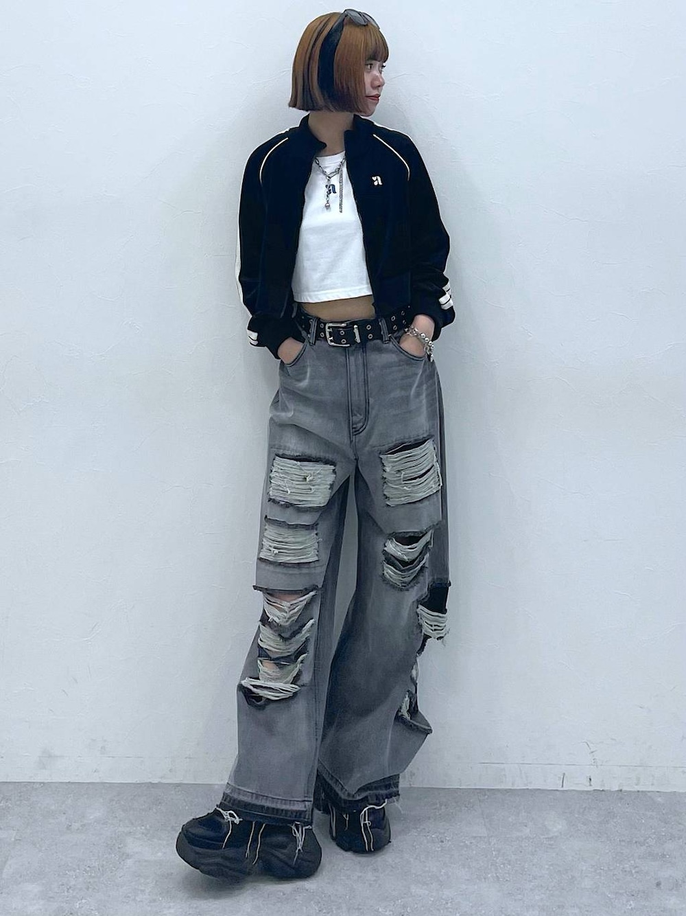 ブラック系のデニムパンツ、ブラック系のスニーカー、ホワイト系のTシャツ/カットソーを着用したレディースの夏コーディネートの1枚目の写真