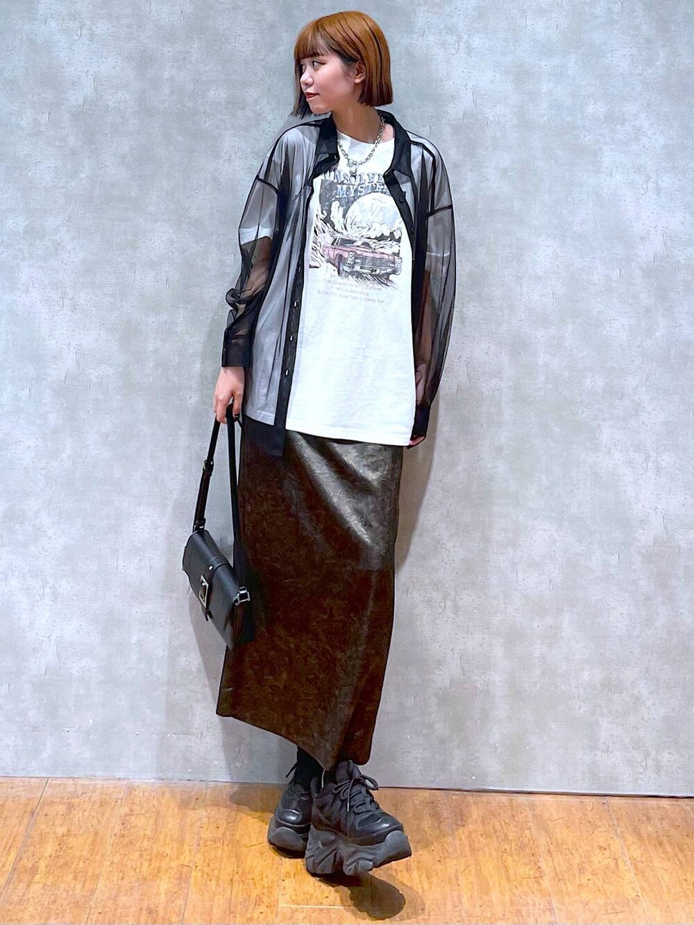 ブラック系のスニーカー、ホワイト系のTシャツ/カットソー、ブラック系のハンドバッグを着用したレディースの夏コーディネートの1枚目の写真