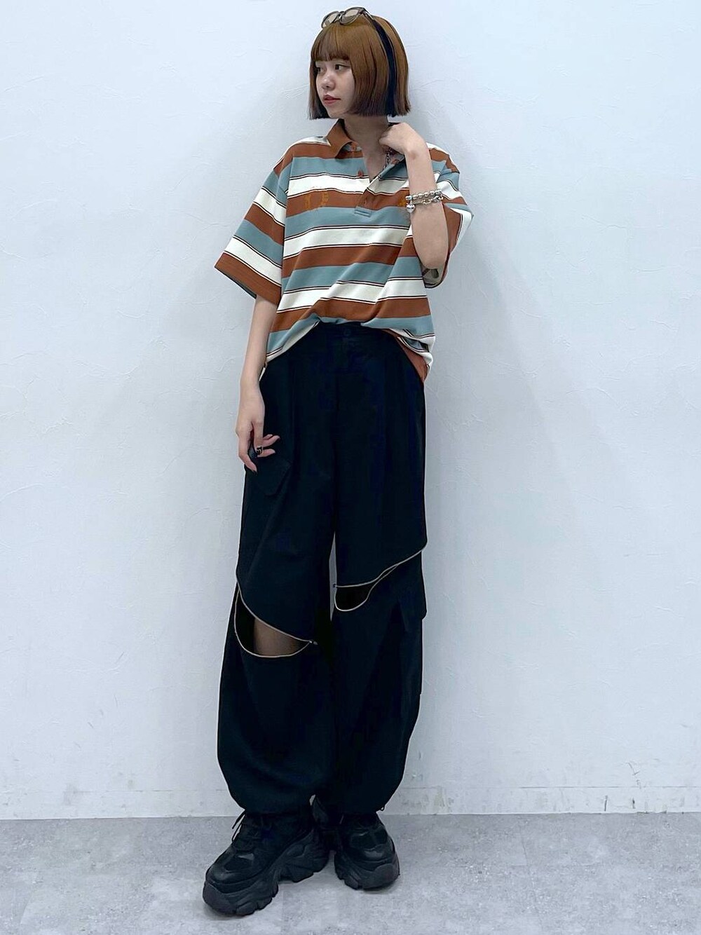 ブラック系のスニーカー、ブラック系のカーゴパンツ、ブラウン系のTシャツ/カットソーを着用したレディースの夏コーディネートの1枚目の写真