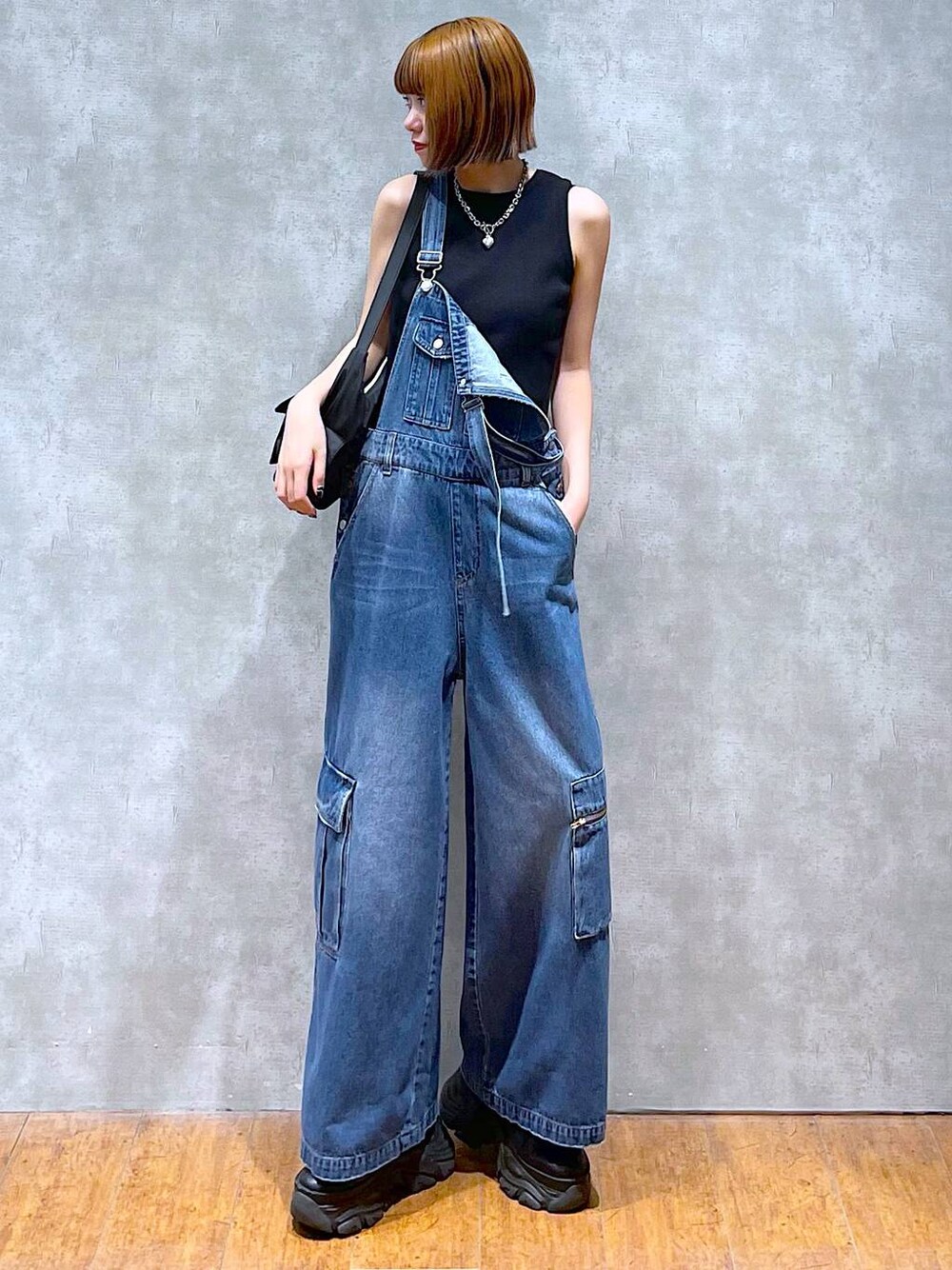 ブラック系のショルダーバッグ、ブラック系のスニーカー、ブラック系のタンクトップを着用したレディースの夏コーディネートの1枚目の写真