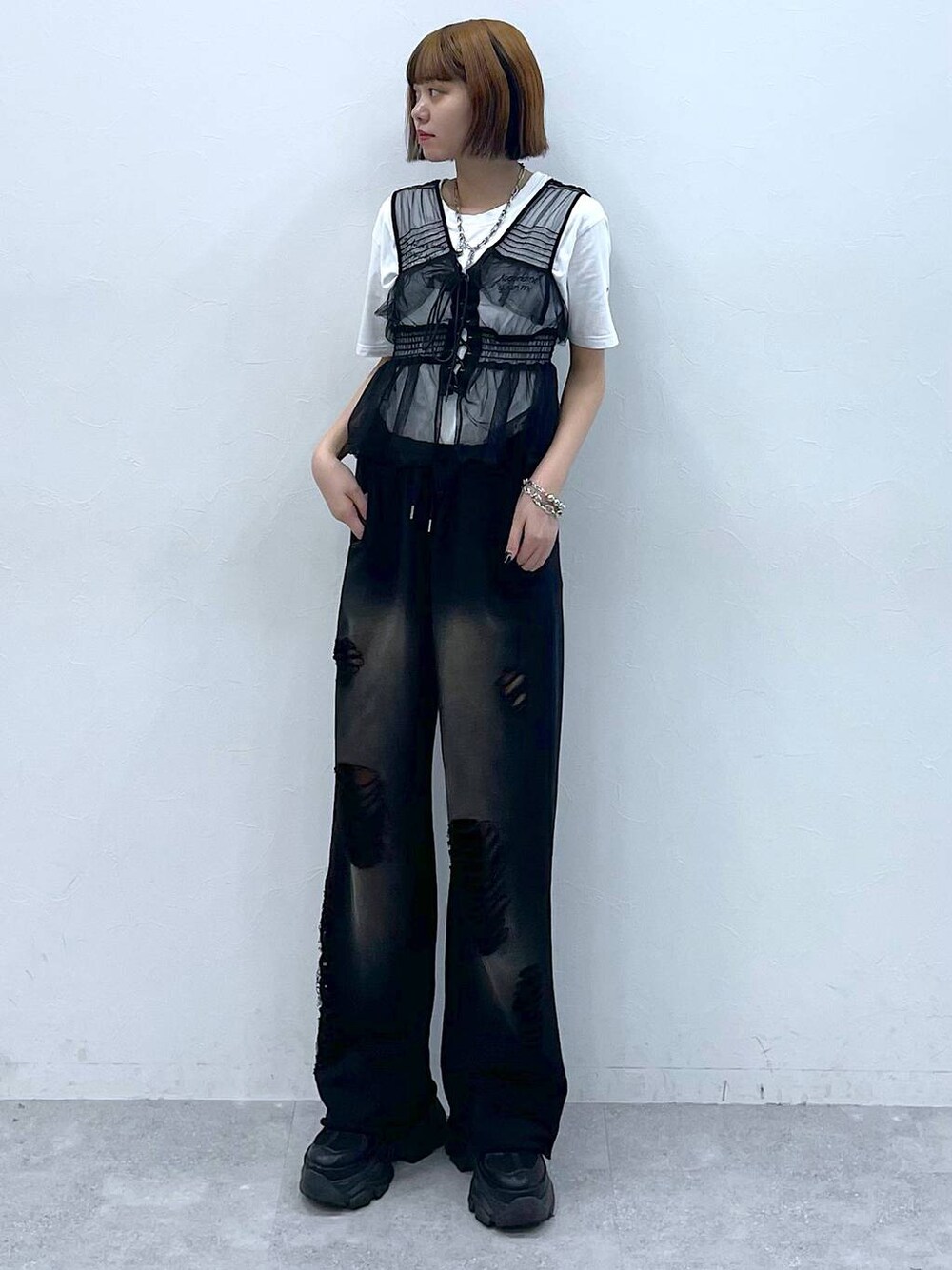 ブラック系のスニーカー、ブラック系のベスト、ホワイト系のTシャツ/カットソーを着用したレディースの夏コーディネートの1枚目の写真