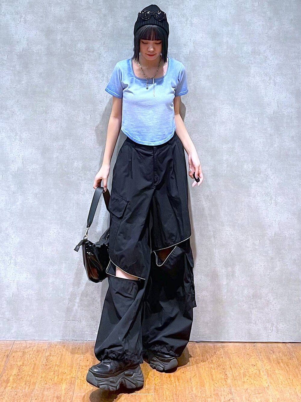 ブラック系のスニーカー、ブラック系のカーゴパンツ、ブルー系のTシャツ/カットソーを着用したレディースの夏コーディネートの1枚目の写真