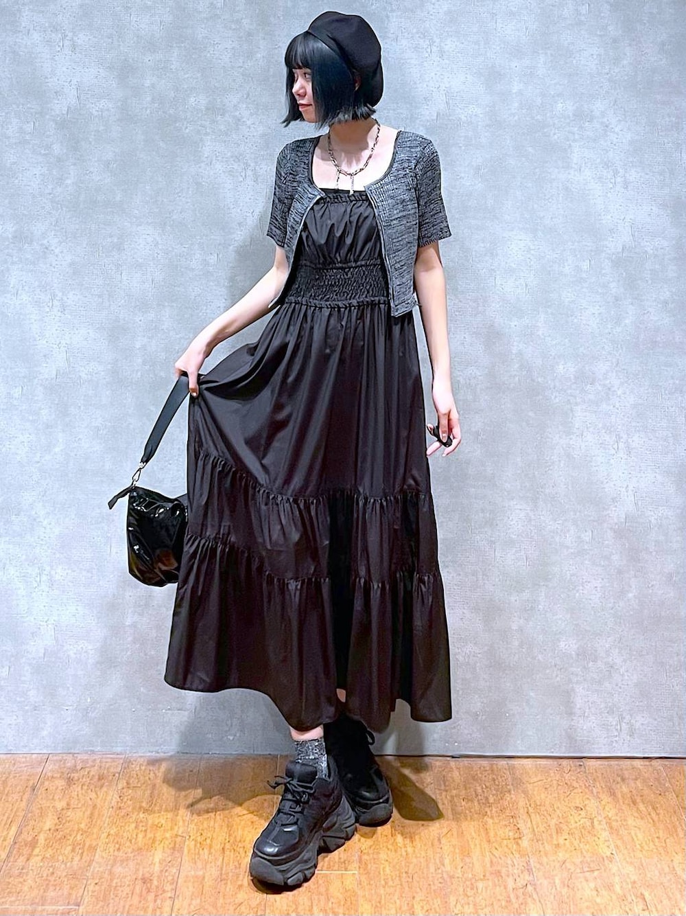 ブラック系のスニーカー、ブラック系のショルダーバッグ、ブラック系のワンピースを着用したレディースの夏コーディネートの1枚目の写真