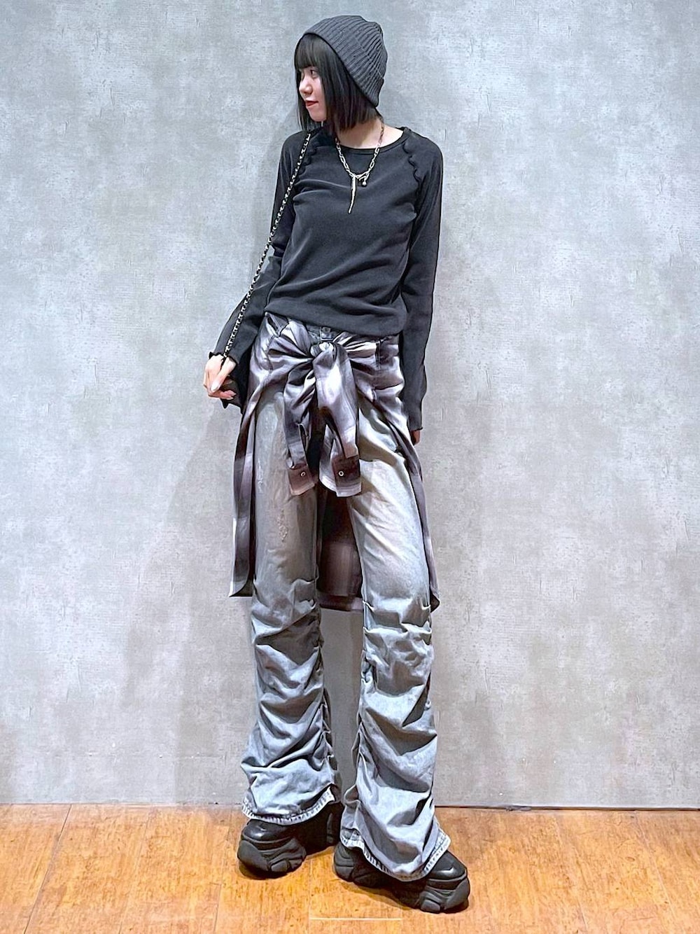 ブラック系のスニーカー、ブルー系のデニムパンツ、グレー系のシャツ/ブラウスを着用したレディースの秋コーディネートの1枚目の写真