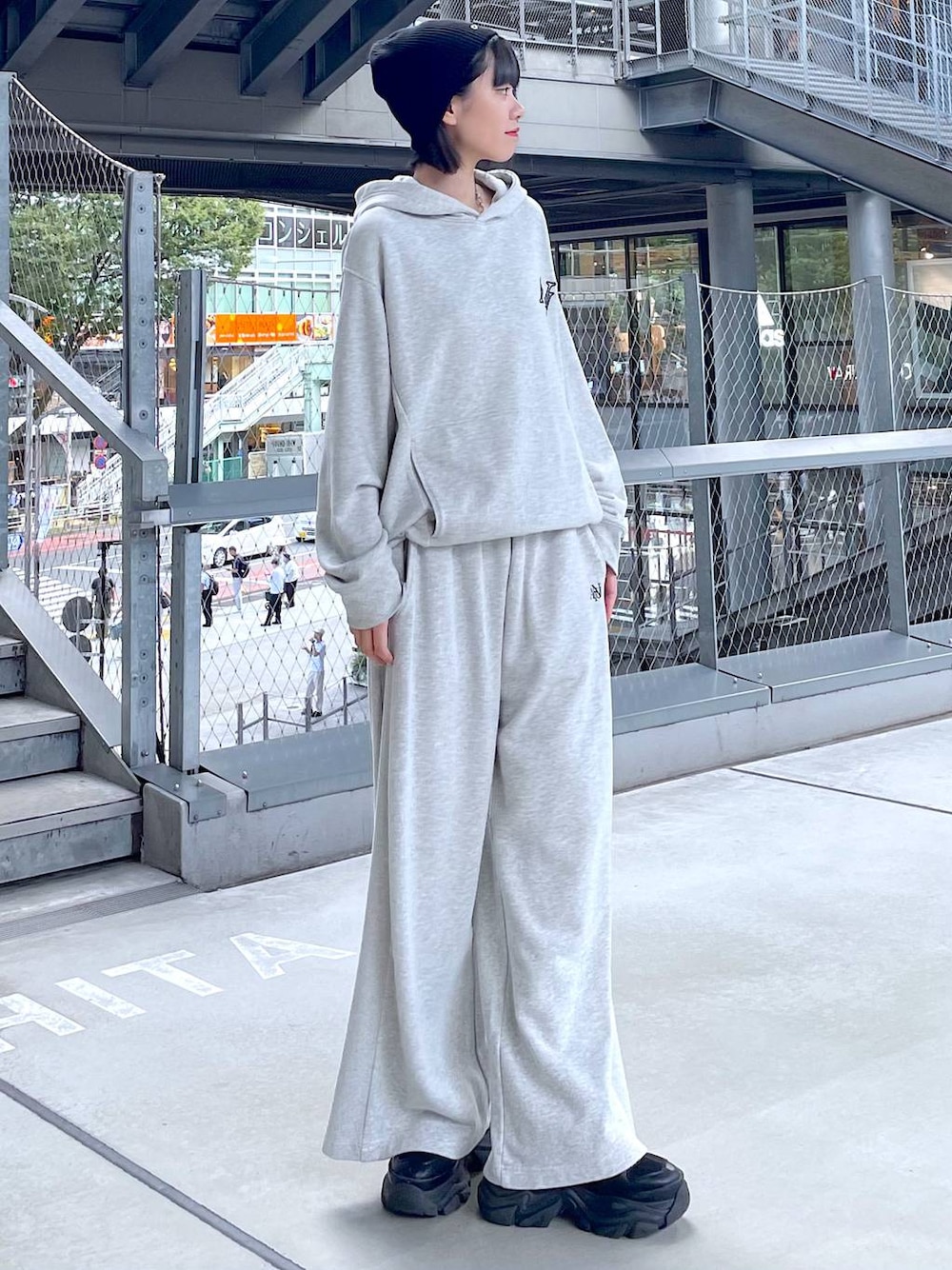 ブラック系のスニーカー、グレー系のパーカー、グレー系のスウェットパンツを着用したレディースの秋コーディネートの1枚目の写真