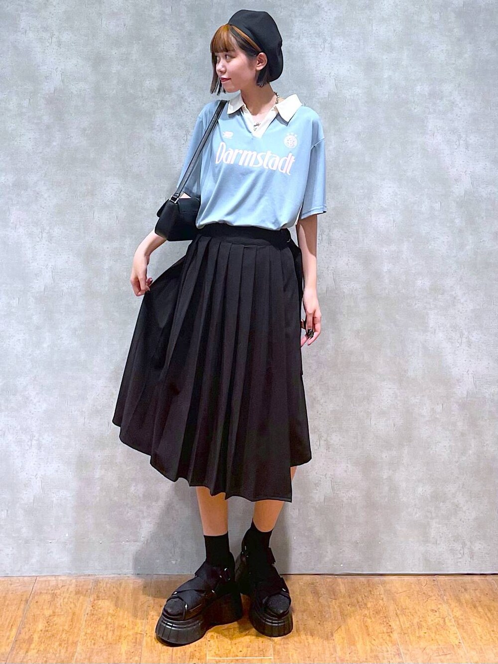 ブラック系のスニーカー、ブラック系のスカート、ブラック系のハンドバッグを着用したレディースの夏コーディネートの1枚目の写真