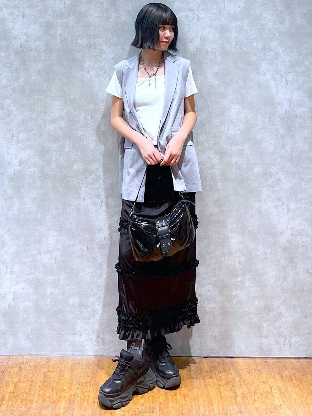 ブラック系のスニーカー、ホワイト系のTシャツ/カットソー、ブラック系のショルダーバッグを着用したレディースの夏コーディネートの1枚目の写真