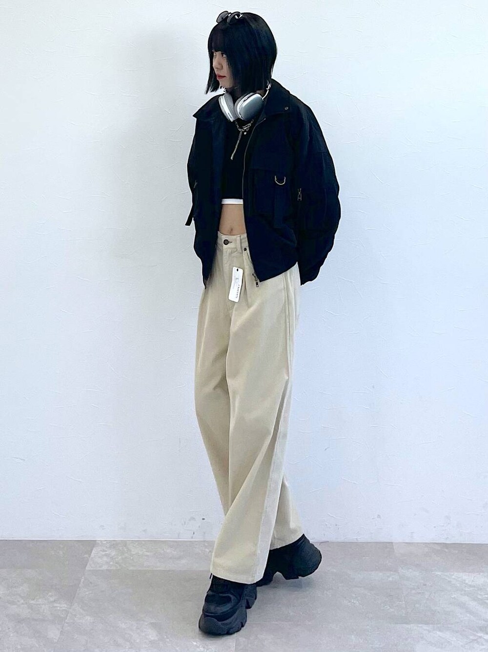 ブラック系のスニーカー、ブラック系のTシャツ/カットソー、ホワイト系のキャミソールを着用したレディースの秋コーディネートの1枚目の写真