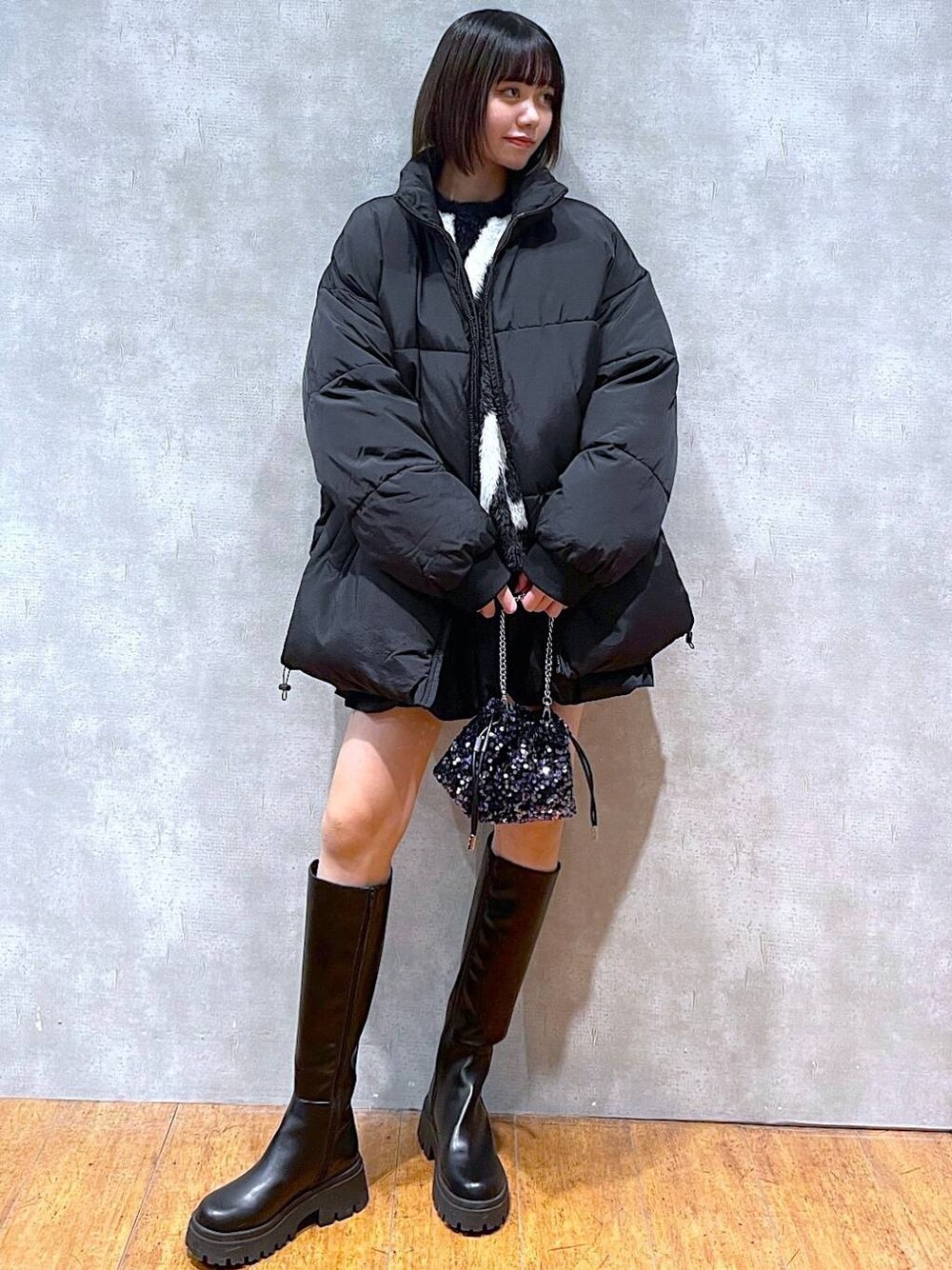 ブラック系のスカート、ブラック系のブーツ、ブラック系のダウンジャケット/コートを着用したレディースの冬コーディネートの1枚目の写真