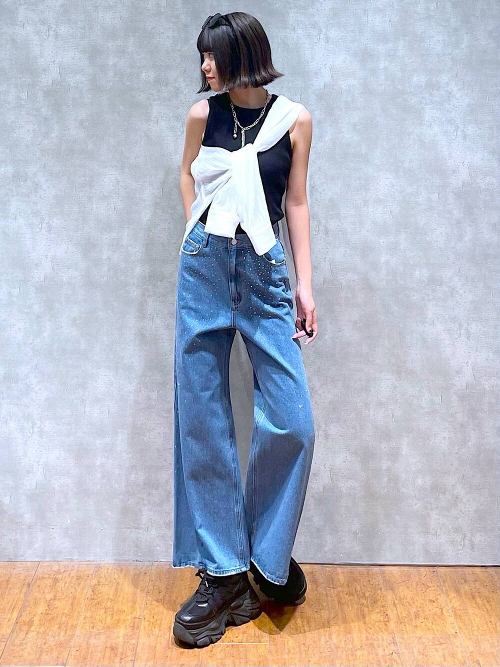 ブラック系のスニーカー、ブラック系のタンクトップ、ブルー系のデニムパンツを着用したレディースの夏コーディネートの1枚目の写真