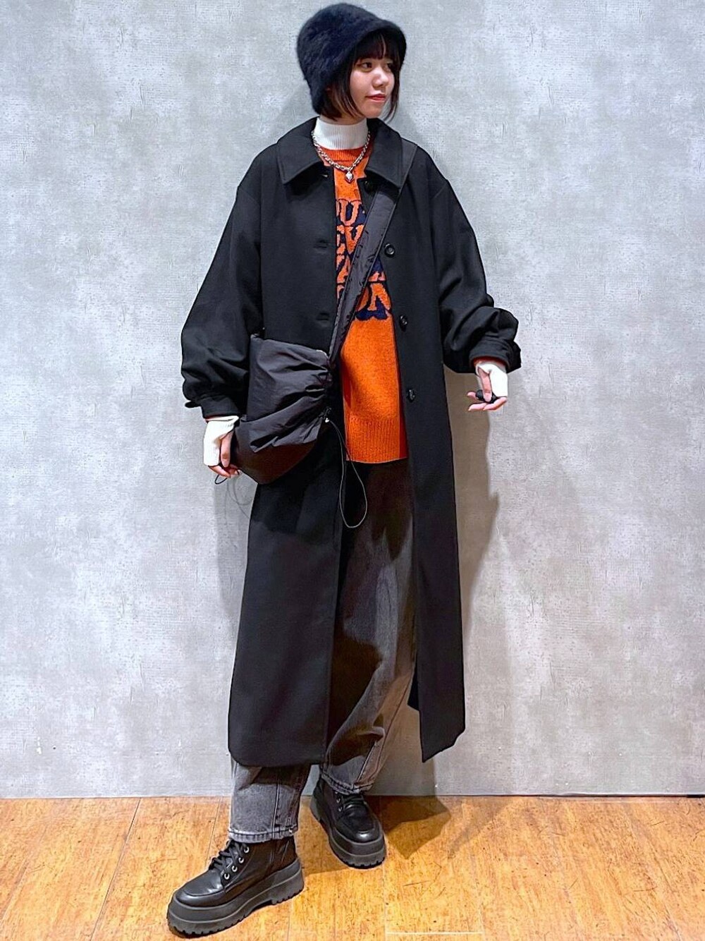 ブラック系のブーツ、ブラック系のチェスターコート、ブラック系のデニムパンツを着用したレディースの冬コーディネートの1枚目の写真