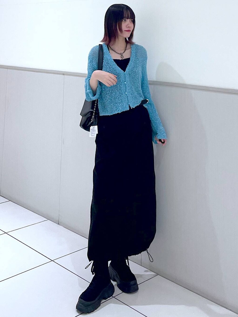 ブラック系のショルダーバッグ、ブラック系のタンクトップ、ブラック系のブーツを着用したレディースの春コーディネートの1枚目の写真