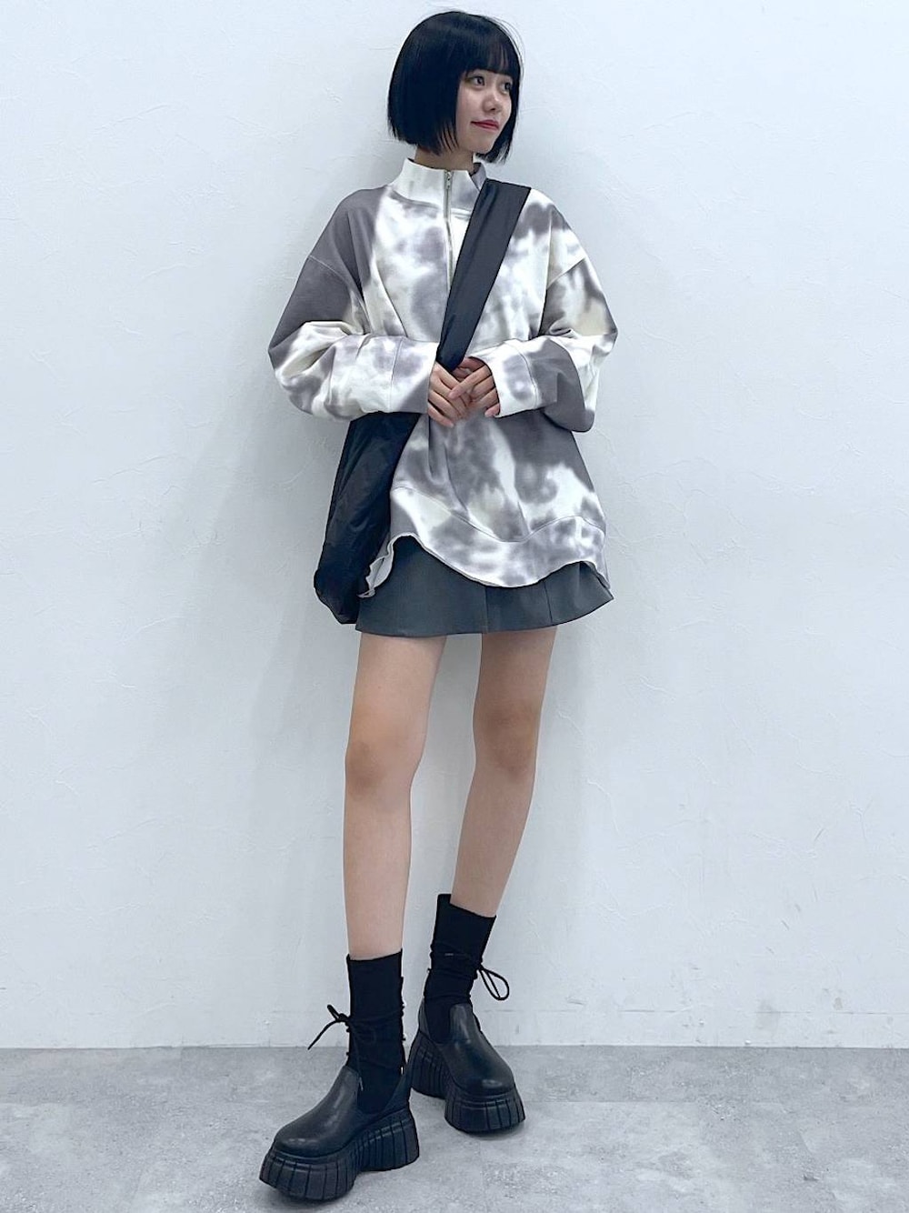 ブラック系のトートバッグ、ブラック系のブーツ、ホワイト系のTシャツ/カットソーを着用したレディースの冬コーディネートの1枚目の写真