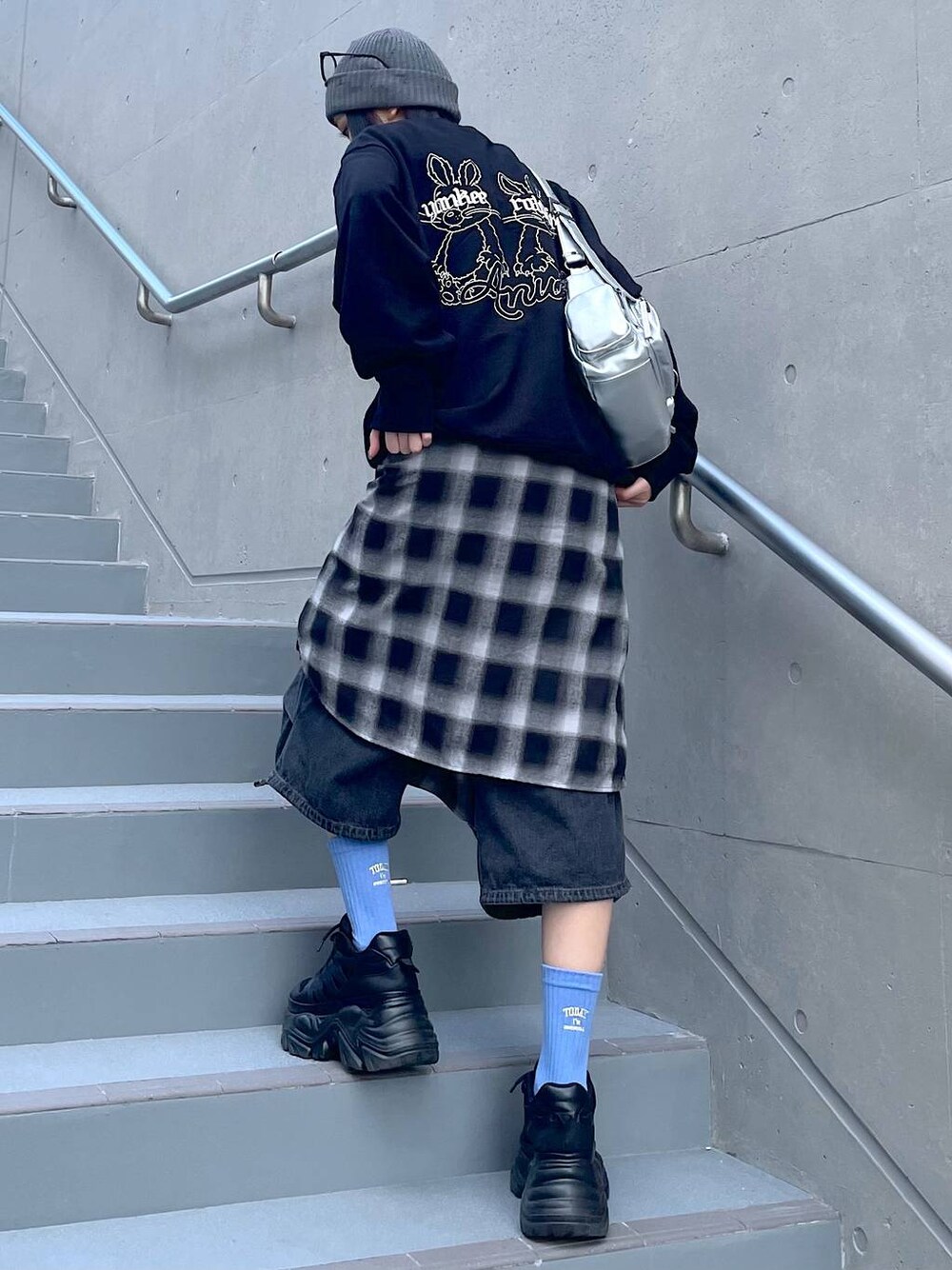 ブラック系のスニーカー、ブラック系のシャツ/ブラウス、ブラック系のデニムパンツを着用したレディースの秋コーディネートの1枚目の写真