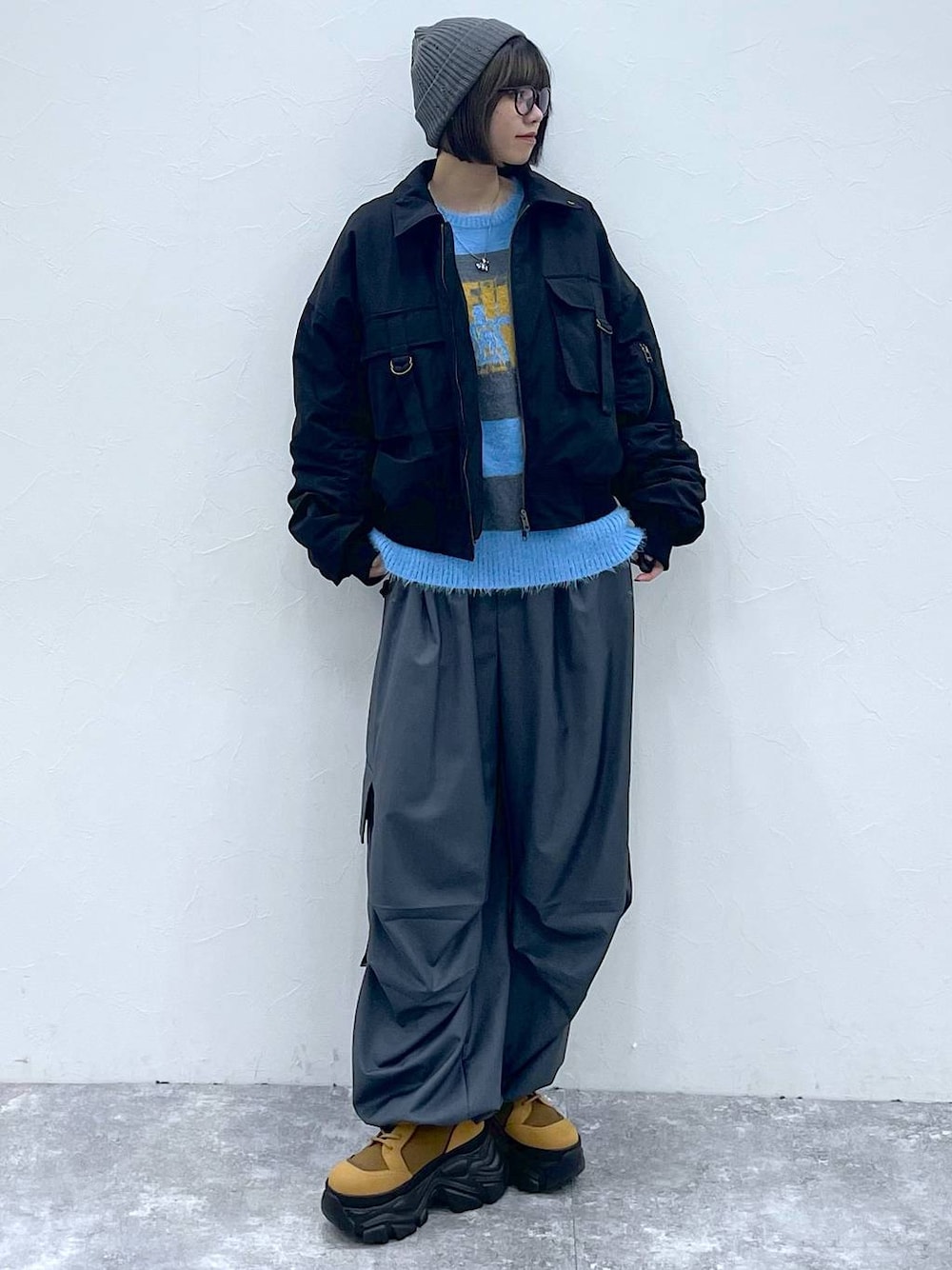 ブラウン系のブーツ、ブラック系のブルゾン、グレー系のカーゴパンツを着用したレディースの秋コーディネートの1枚目の写真