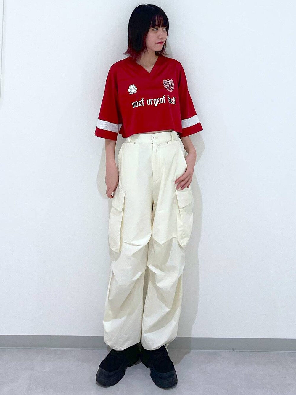 ホワイト系のカーゴパンツ、ブラック系のブーツ、レッド系のTシャツ/カットソーを着用したレディースの春コーディネートの1枚目の写真