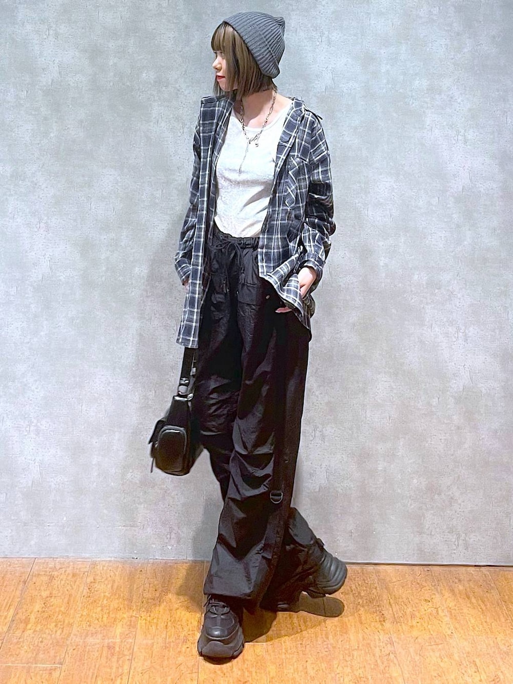 ブラック系のスニーカー、ブラック系のカーゴパンツ、ブルー系のシャツ/ブラウスを着用したレディースの秋コーディネートの1枚目の写真