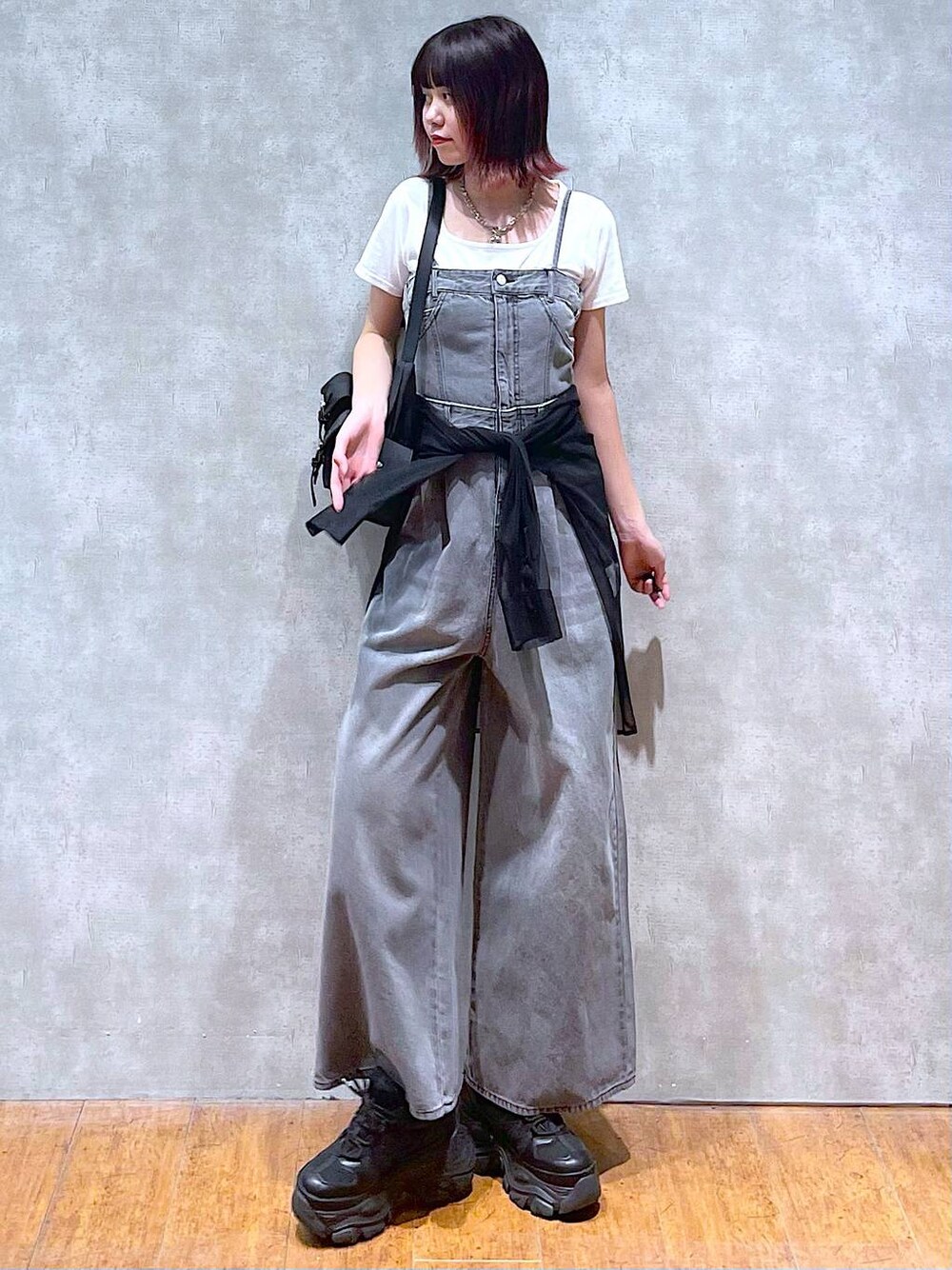 ブラック系のショルダーバッグ、ブラック系のサロペット/オーバーオール、ブラック系のスニーカーを着用したレディースの春コーディネートの1枚目の写真