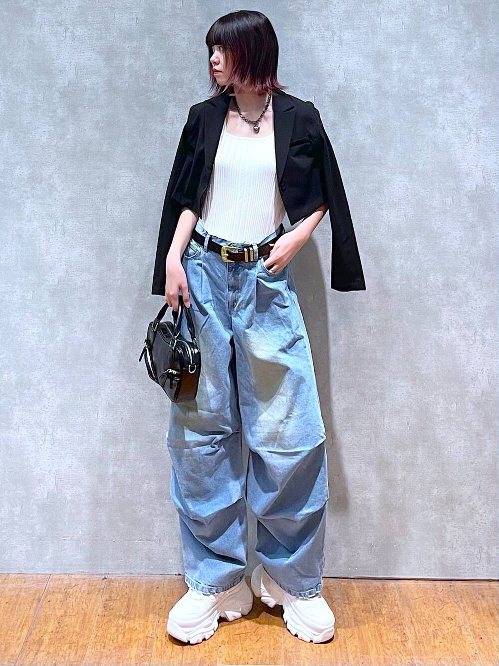 ホワイト系のタンクトップ、ホワイト系のスニーカー、ブラック系のボストンバッグを着用したレディースの春コーディネートの1枚目の写真