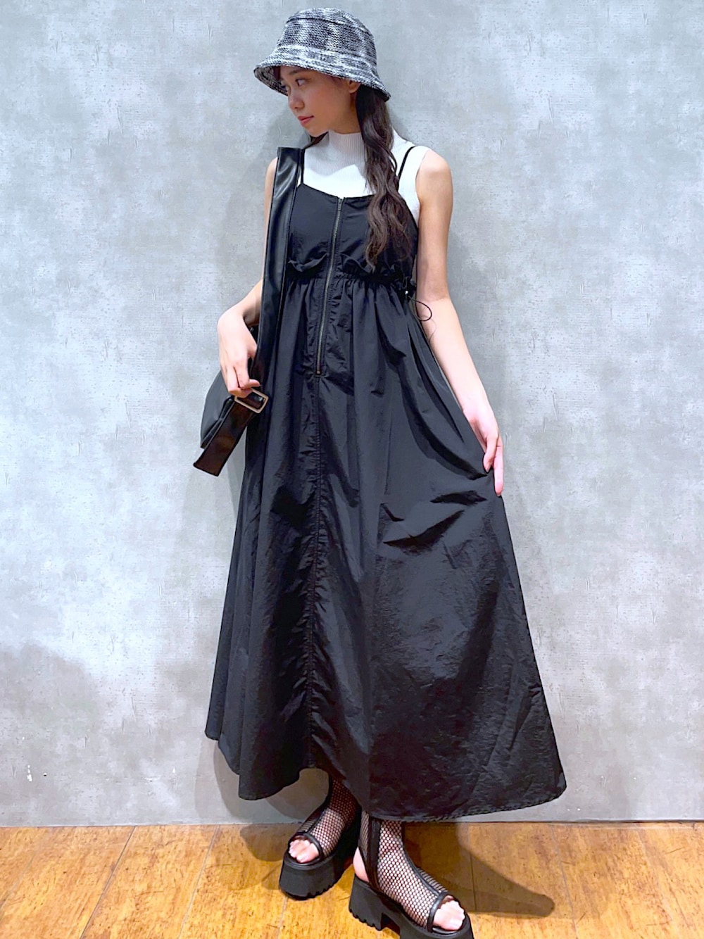 ブラック系のショルダーバッグ、ブラック系のワンピース、ホワイト系のTシャツ/カットソーを着用したレディースの夏コーディネートの1枚目の写真