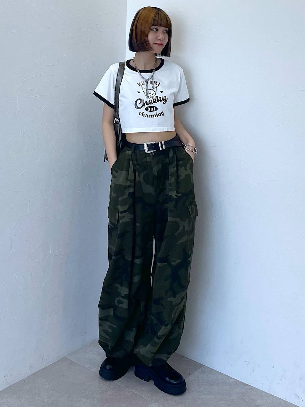 ブラック系のブーツ、グリーン系のカーゴパンツ、シルバー系のブレスレットを着用したレディースの夏コーディネートの1枚目の写真