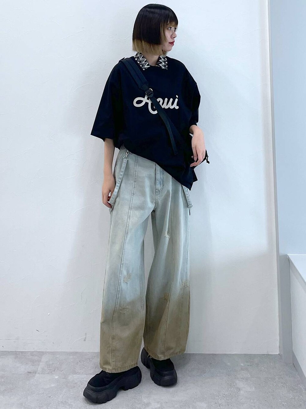 ブラック系のTシャツ/カットソー、ブラック系のボディバッグ/ウエストポーチ、ブラック系のブーツを着用したレディースの春コーディネートの1枚目の写真