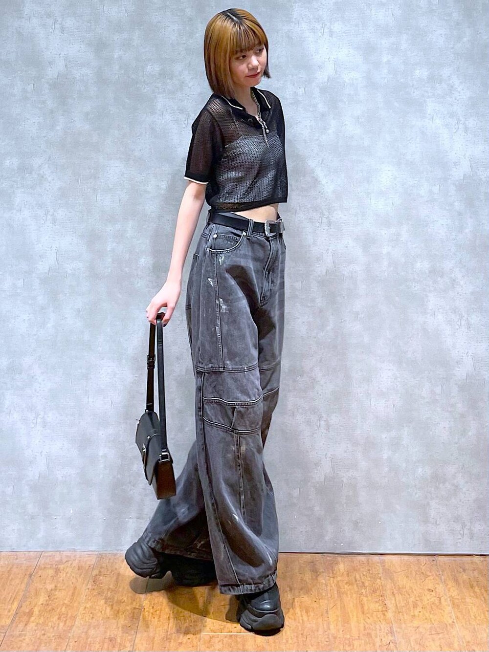 ブラック系のスニーカー、ホワイト系のキャミソール、ブラック系のデニムパンツを着用したレディースの夏コーディネートの1枚目の写真